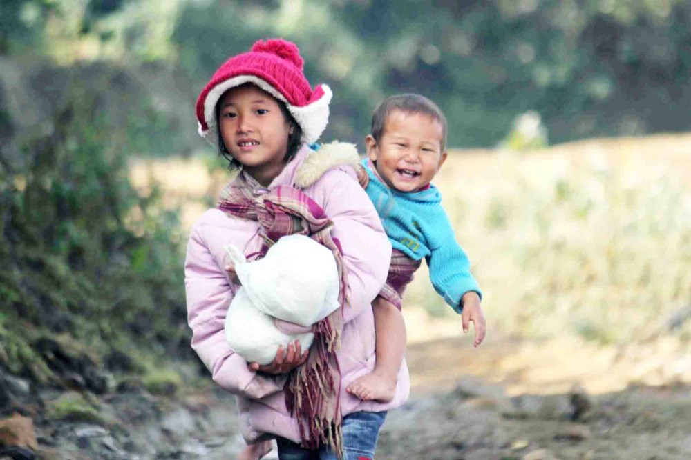 A young girl running errands carrying her younger brother on her back at Waoshu Village, a Chang Naga village, Tuensang District. Photo: Toshi Kichu
